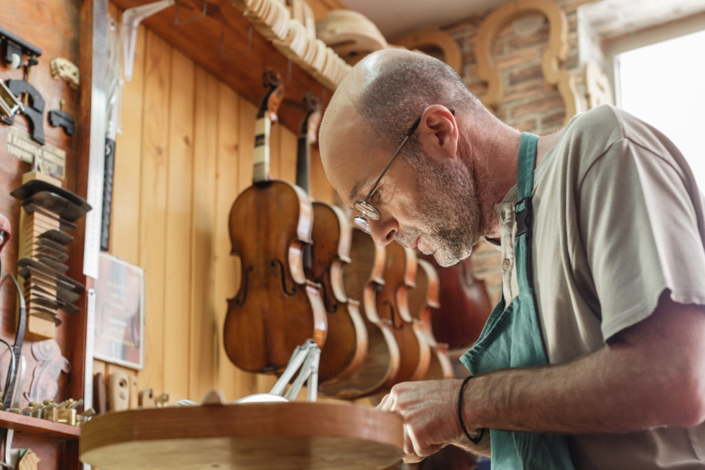 Violin maker being absorbed by work on a new instrument